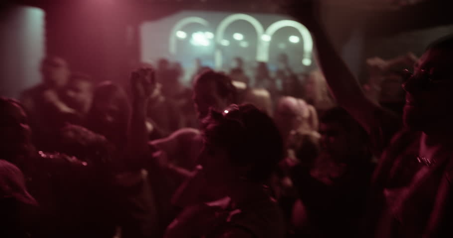 Diverse Party Crowd Enjoying Time in an Underground Nightclub, Dancing Energetically Under Dynamic Lights and Pulsating Music. Young Men and Women Having an Emotional Night Out