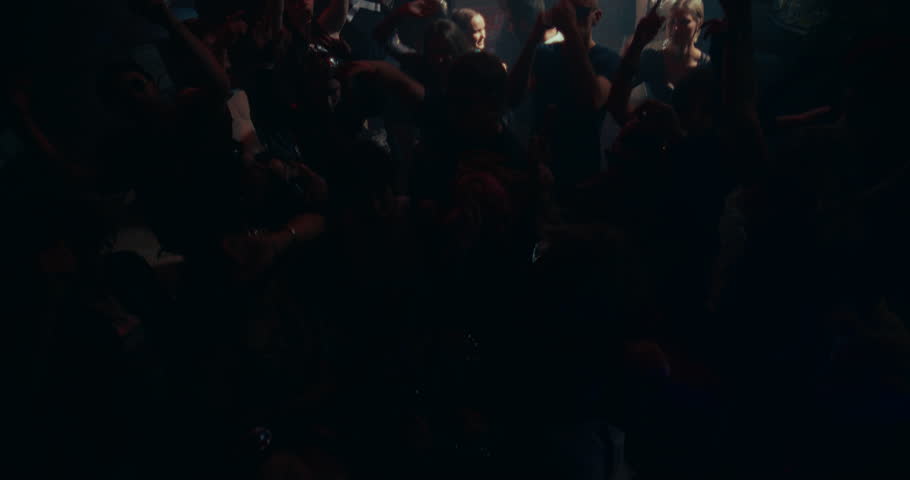 Partygoers Dancing in a Club with Colorful Strobe Lights. Young Adults Enjoying a Night Out at an EDM Party. Stylish Men and Women Enjoying a Disco at a Nightclub. Slow Motion High Angle Footage