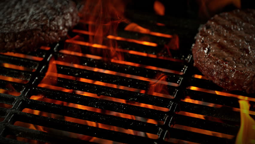 Super Slow Motion Shot of Hamburger Meat Falling on Fired Up Grill with Camera Motion at 1000fps.