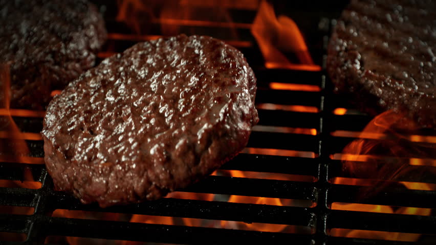 Super Slow Motion Shot of Hamburger Meat Falling on Fired Up Grill with Camera Motion at 1000fps.