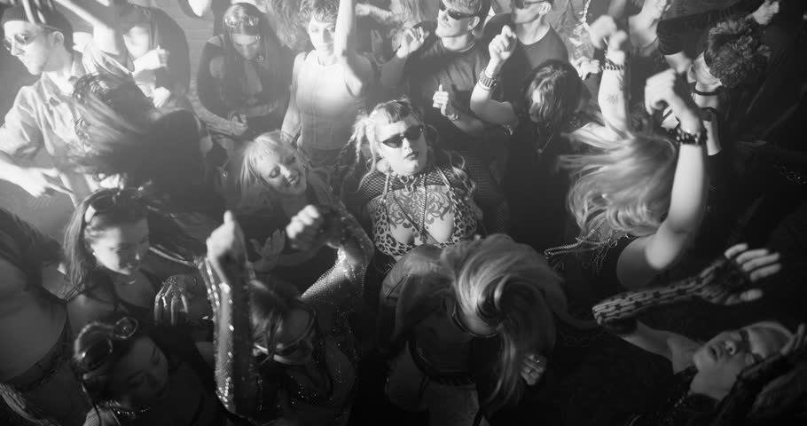 Party Crowd Enjoying Time in a Nightclub, Dancing Energetically Under Lights and Pulsating Music. Young Men and Women Having an Emotional Night Out. Slow Motion Top Down Black and White Footage