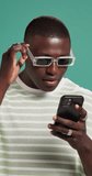 Surprise, fashion or black man with phone in studio for winning discount, sale or bargain deal. Wow, notification or excited person in trendy sunglasses, shock or cool clothes on green background - Powered by Shutterstock - Get 15% off with code: PIKWIZARD15