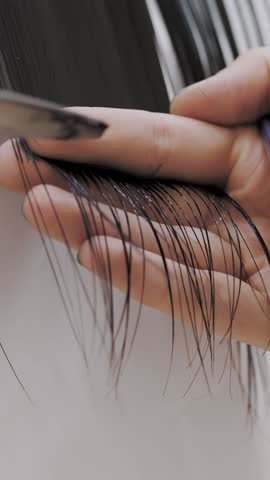 Haircut. Hair care. Close-up. Barber is cutting long hair using tools such as comb and scissors. Beauty salon. Barber shop.