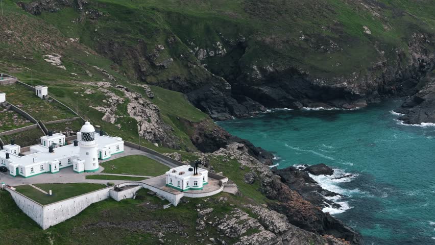 Retreating circle left drone overview from Pendeen Lighthouse out toward open ocean, aerial