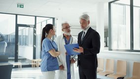Medical sales representative presenting new medication to doctors, standing hospital hallway. - Powered by Shutterstock - Get 15% off with code: PIKWIZARD15