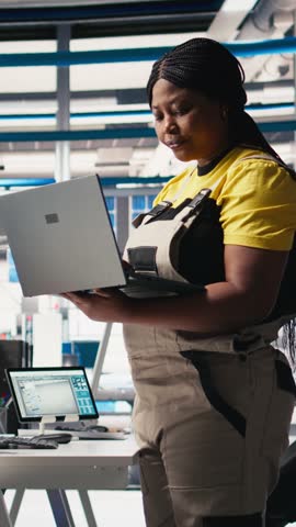 Vertical Video Photovoltaics factory technician designing CAD models and technical sketches for solar modules on laptop. Woman engineer ensures solar panel designs for efficiency and manufacturability