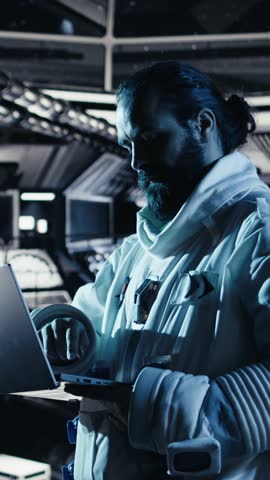 Vertical video Cheerful female astronaut records selfie video with smartphone, speaking to subscribers during galactic mission. Jolly african american woman in starship recording content for followers