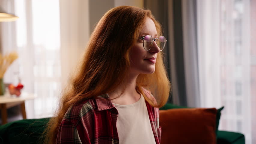 Joyful Caucasian girl female woman happy smiling falling couch cozy home sitting on sofa rest chilling at living room satisfied lady relaxing own rent apartment domestic relocation moving day mortgage