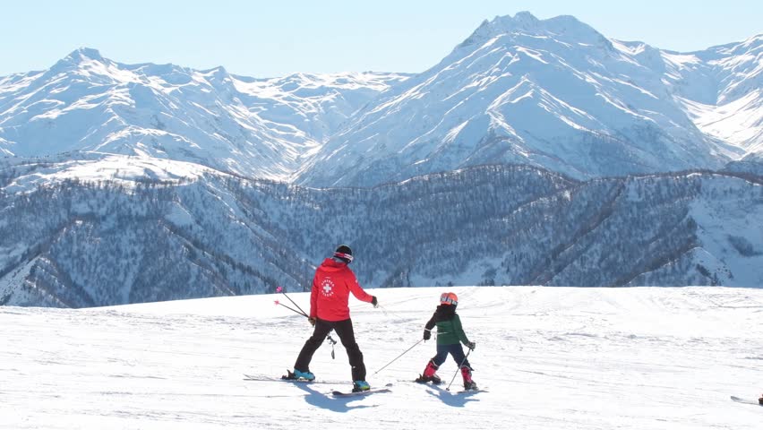 Mestia, Georgia - 11th january, 2025: georgian male ski instructor give ski lesson teach skiing young child. Professional ski guidance, winter sport education, old technique, childhood development