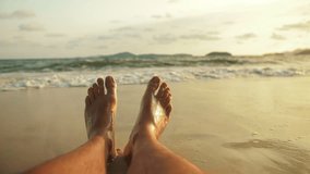 The barefoot man feet relaxed are lying on the sandy beach and washed by the water and foam of the ocean. Concept relax tropical resort traveling happy summer holiday - Powered by Shutterstock - Get 15% off with code: PIKWIZARD15