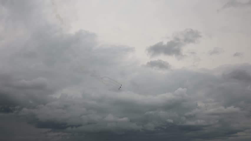 Airshow planes dive in sharp formation under dramatic storm clouds leaving dark smoke trails slicing through the moody sky as thunder looms in the distance with cinematic intensity