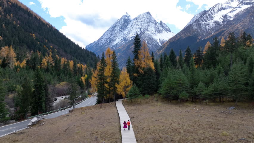 Tourists walking at Siguniangshan in autumn, Sichuan in China.