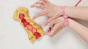 Strawberry dessert on white table and female hands measuring tape. Nutritionist pulls centimeter away, stopping girl from eating. Healthy lifestyle, avoid junk food. - Powered by Shutterstock - Get 15% off with code: PIKWIZARD15
