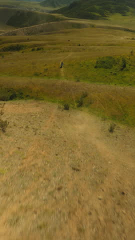 Rider slices across challenging landscape. Motorcycle tires churning up dust as example of vivid symbol of exhilaration inherent in extreme motocross