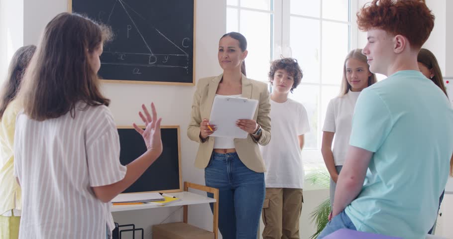 School children and teacher gathered in class, coworking, solve, listen to teen team leader during debate, share information, corporate goals, tell, speech on public meeting, child opposing arguments