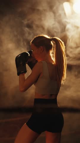 Self-defense classes for women, be strong and powerful, young lady training. Slender woman striking punching bag, practicing alone in fitness club, motivated sportsperson developing endurance of body