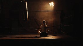Female boxer resting after workout on boxing ring, sitting in lotus position. Relax and recover body force after intense cardio training, stay calm and self-confident, move to win, women power - Powered by Shutterstock - Get 15% off with code: PIKWIZARD15
