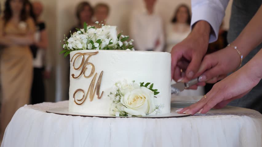 Beautiful wedding cake being cut by the bride and groom. Wedding celebration traditions.