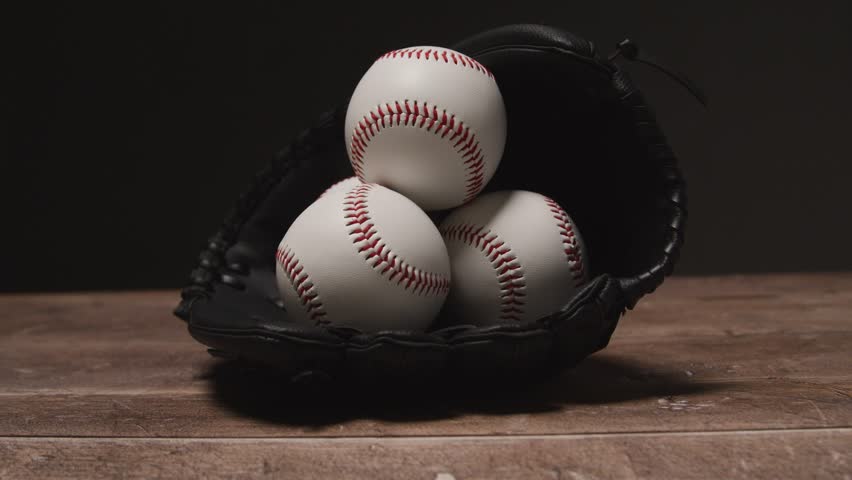 close up studio baseball still life with balls in catchers mitt on wooden floor 3 stock video