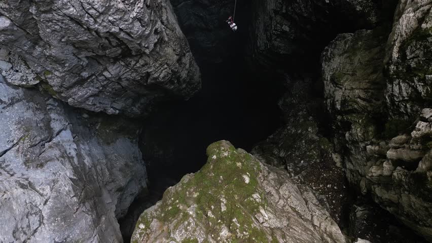 Aerial view of a scientific instrument being lowered into a 188-metre natural cleft in a mountain, Nikolina Jama, Montenegro
