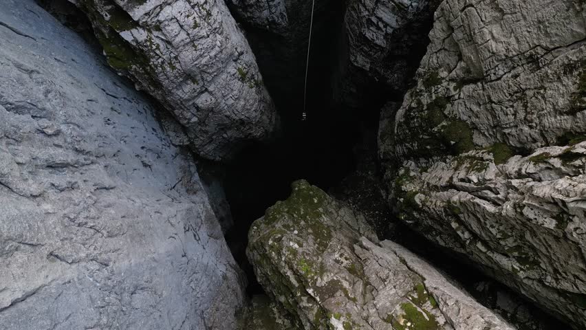 Aerial view of a scientific instrument being lowered into a 188-metre natural cleft in a mountain, Nikolina Jama, Montenegro