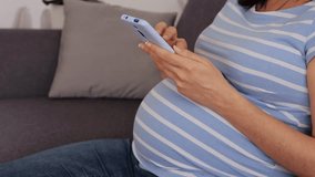 Pregnant woman using smartphone on sofa - Powered by Shutterstock - Get 15% off with code: PIKWIZARD15