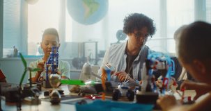 Team of Smart Kids and Young Teacher Assembling Constructor on STEM Lesson in Multiethnic Classroom. Primary School Children Exploring Robotics, Renewable Energy Models, Studying Modern Technologies. - Powered by Shutterstock - Get 15% off with code: PIKWIZARD15