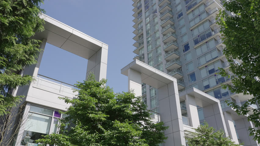 Establishing shot. Top of modern apartment building with nice windows in Summer in Vancouver, Canada, North America. Day time on May 2025. Still camera view. ProRes 422 HQ.