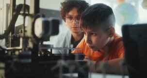 Elementary School Student Watching Printing Process on Automated 3D Printer During Programming Lesson. Teacher Educating Technology to Smart Young Boy in Modern Classroom. Interactive STEM Education. - Powered by Shutterstock - Get 15% off with code: PIKWIZARD15