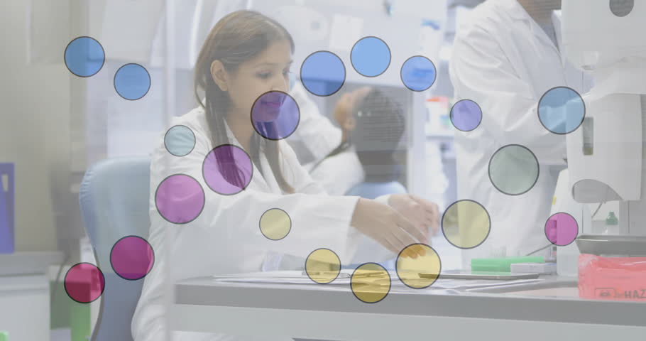 Indian female lab technician organizing slides then tapping tablet displaying data in research lab. Research, collaboration, analysis, scientific, technology, innovation, professional
