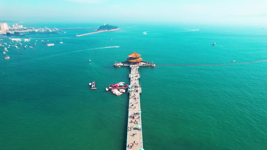Aerial view of summer tourists walking around Qingdao Trestle Bridge in China during the daytime