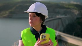 Female engineer using smartphone near dam in slow motion - Powered by Shutterstock - Get 15% off with code: PIKWIZARD15