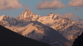 4K Time lapse of clouds moving over snowy mountains during sunset at Rohtang, Himachal Pradesh, India. Mesmerizing Himalaya landscape with orange sunlight on snowy Himalaya mountains.  - Powered by Shutterstock - Get 15% off with code: PIKWIZARD15