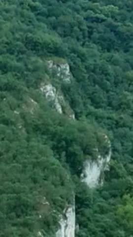 Dense Green Mountain Forest with Steep Cliff Rock Formations