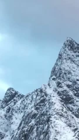 Sharp Snow-Covered Rocky Mountain Peaks under Overcast Winter Sky