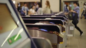 Crowd of People walking pass ticket gate in subway station in rush hour morning. Passenger using card and smartphone mobile app making payment for public transportation at train station in the city. - Powered by Shutterstock - Get 15% off with code: PIKWIZARD15