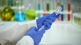 Doctor prepare syringe vaccine in protective suit disease prevention immunization Female doctor or nurse holding syringe with liquid in slow motion - Powered by Shutterstock - Get 15% off with code: PIKWIZARD15