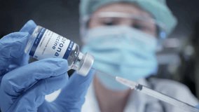 nurse prepares a syringe for an injection Medium closeup studio shot of a young caucasian female doctor in protective gear face mask Hospital staff - Powered by Shutterstock - Get 15% off with code: PIKWIZARD15