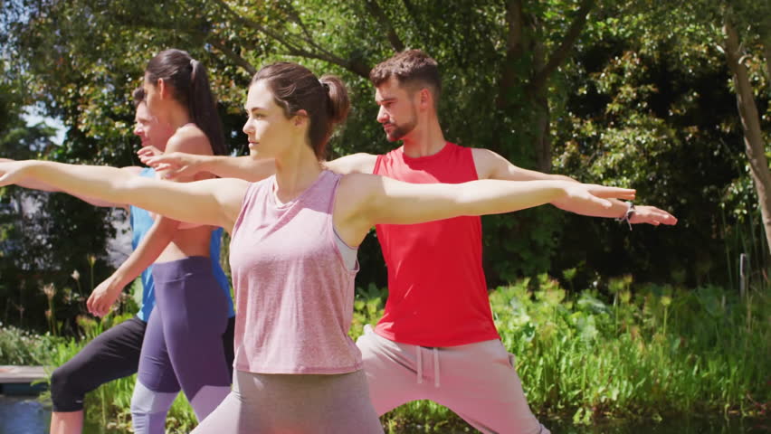 Fitness group holding Warrior II on yoga mats after heart-eyes emoji sparking emojis filling scene. Wellness, harmony, outdoor, tranquility, mindfulness, nature, camaraderie
