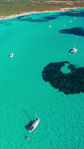 Aerial view of the stunning Mediterranean Sea coast in Mallorca, Balearic Islands, Spain. Peacefully moored sailboats in the incredible turquoise waters of Mallorca island.