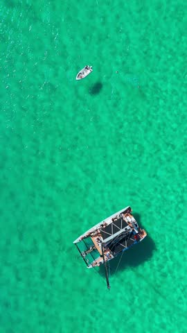 Aerial top down view of a beautiful modern sailboat is moored in the incredible turquoise waters of the Mediterranean Sea in Mallorca, Balearic Islands, Spain. 