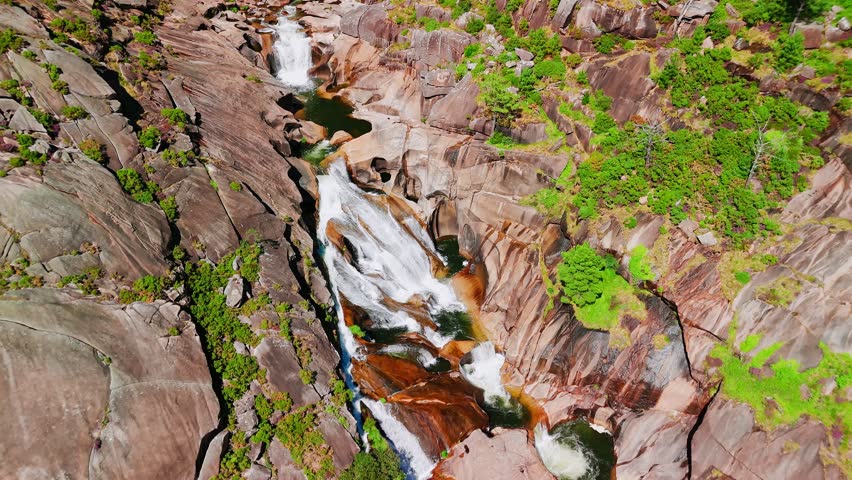 Aerial view of the beautiful Ezaro waterfall in Carnota, Galicia, northern Spain. The Xallas River flows into the stunning cascade waterfall, cascading through a deep canyon during the summer season.