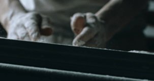 Cinematic Super slow motion close up of professional artisan baker chef sprinkles flour on raw loaf of dough while making homemade bread, pasta or pizza on rustic wooden table in traditional bakery ki - Powered by Shutterstock - Get 15% off with code: PIKWIZARD15