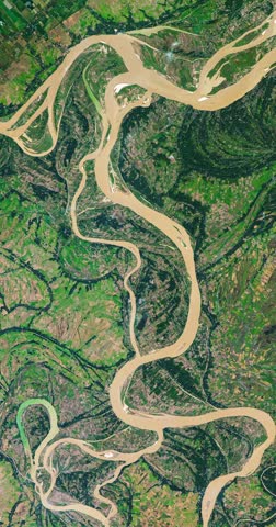 Panoramic shot on meanders of river in agricultural region with many parcels of land. Camera is moving backward. Vertical video. Animation based on image by NASA