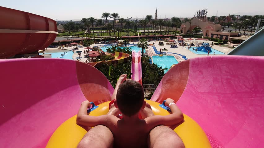 Sliding down a water park slide on a father-son vacation