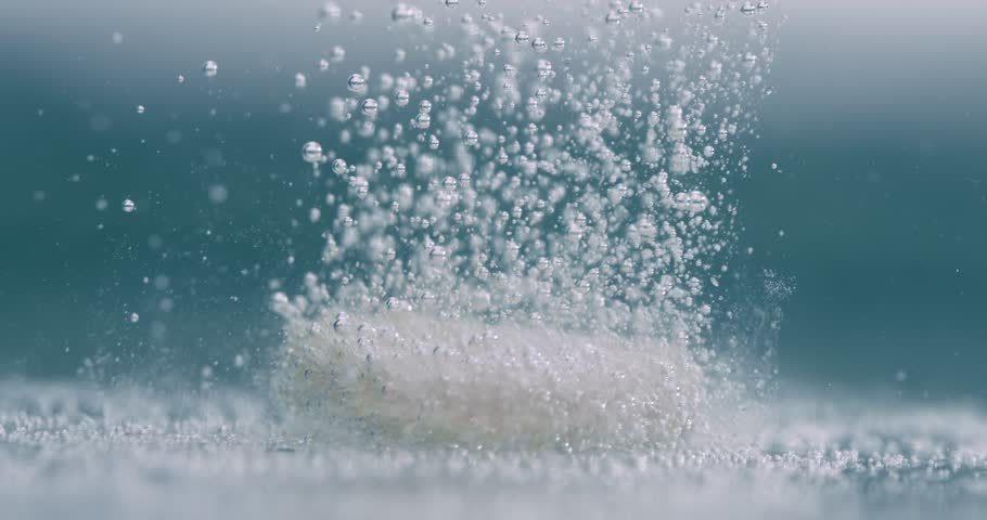 Extreme Close-up effervescent tablet, pill bubbling underwater. Shot on super slow motion camera 1000 fps.