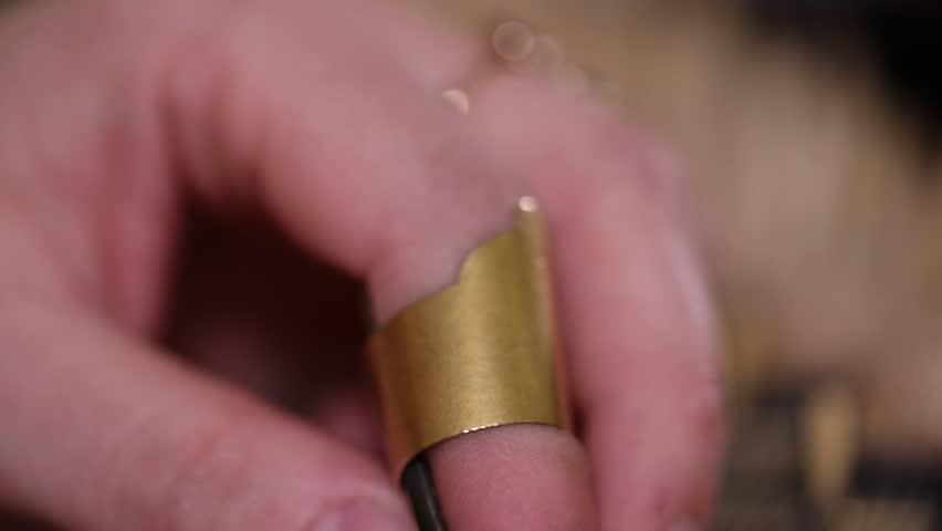 close-up shows a woman's hands playing an ornate wooden zither with plectrums. A microphone captures the beautiful sound of this traditional Middle Eastern folk instrument.