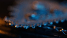 Close-up pan from a patterned fabric belt to its ornate, traditional filigree metal buckle. Dramatic blue and warm lighting highlights the intricate details and craftsmanship. - Powered by Shutterstock - Get 15% off with code: PIKWIZARD15