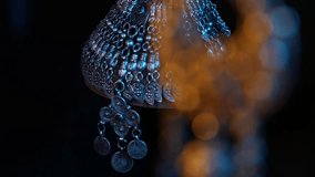 Close-up pan from a patterned fabric belt to its ornate, traditional filigree metal buckle. Dramatic blue and warm lighting highlights the intricate details and craftsmanship. - Powered by Shutterstock - Get 15% off with code: PIKWIZARD15