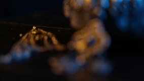 Close-up pan from a patterned fabric belt to its ornate, traditional filigree metal buckle. Dramatic blue and warm lighting highlights the intricate details and craftsmanship. - Powered by Shutterstock - Get 15% off with code: PIKWIZARD15